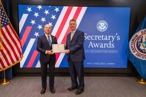 DHS Secretary Alejandro Mayorkas with Team Excellence Award recipient, Charles R. Gillum.