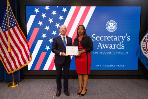 DHS Secretary Alejandro Mayorkas with Team Excellence Award recipient, Kamillah Connolly.
