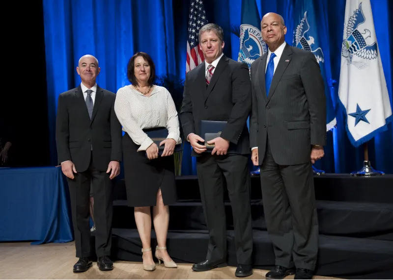 Secretary of Homeland Security Jeh Johnson and Deputy Secretary of Homeland Security Alejandro Mayorkas award the Secretary's Meritorious Service Medal to U.S. Citizenship and Immigration Services Secure Mail Team