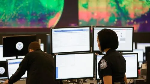 Customs and border protection agents working on computers