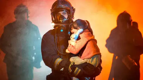Firefighter carrying a child from a fire