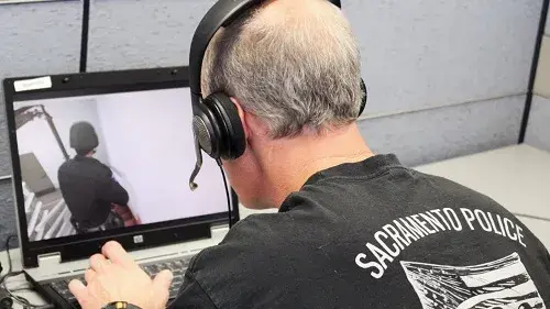 Actual law enforcement officer uses a laptop to command an avatar during a 2013 exercise in Sacramento, California, where EDGE was piloted.
