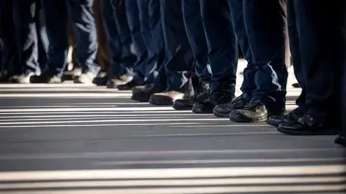 Close up of lower legs of law enforcement officers standing in line