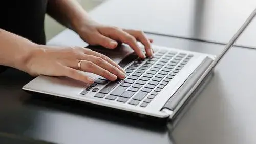 Image of a woman typing on a laptop