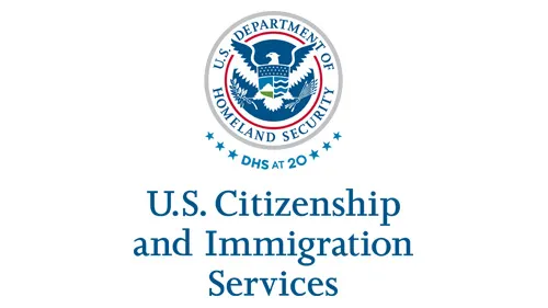 Vertical USCIS wordmark/lockup in blue with "DHS at 20" below the DHS seal