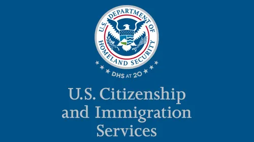 Vertical USCIS wordmark/lockup in gray with "DHS at 20" below the DHS seal