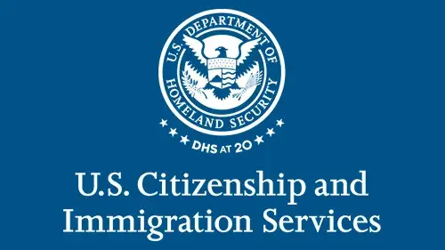 Vertical USCIS wordmark/lockup in monochromatic white with "DHS at 20" below the DHS seal