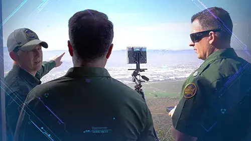 Three border patrol agents surveying border