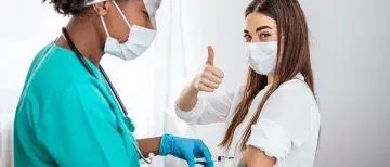 A nurse gives a woman a vaccine