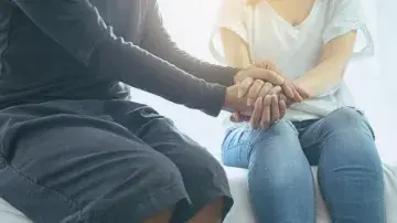 Two people holding hands. 
