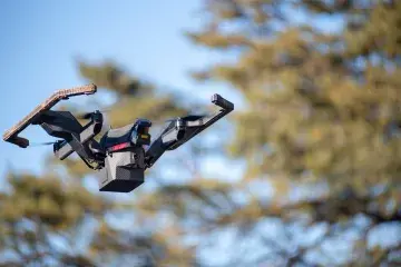 Pegasus II Transformable Air-Ground Robotic System drone flying through the air. In the background – the leaves and branches of trees