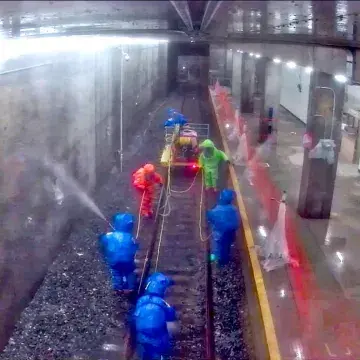 Hazmat-suited team spraying to decontaminate the model subway tunnel