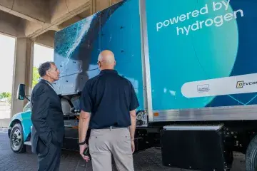 The H2Rescue truck parked on the street under an overpass, with Dr Kuznezov and another man looking at it.