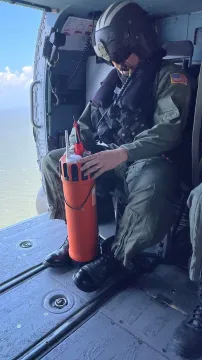 A MOTT buoy being prepared for a drop from an MH-60T helicopter.