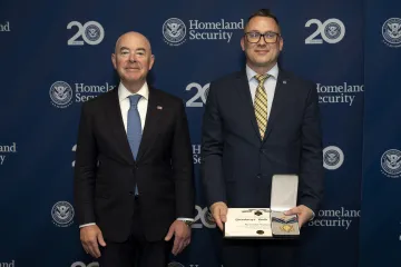 DHS Secretary Alejandro Mayorkas with Secretary's Gold Medal recipient Alexander Stungurys.