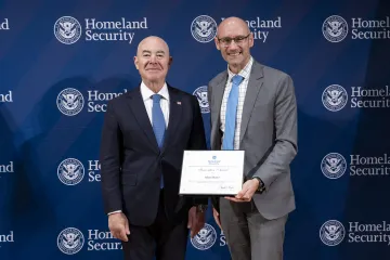 DHS Secretary Alejandro Mayorkas with Innovation Award recipient, Adam Hunter.