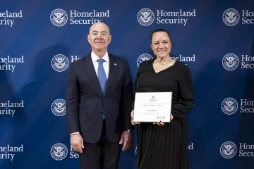 DHS Secretary Alejandro Mayorkas with Team Excellence Award recipient, Monica Mende.