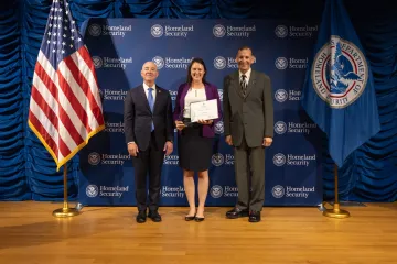 DHS Secretary Alejandro Mayorkas (left) with Innovation Award recipient, Holly Allen (center), and Deputy Under Secretary for Management, Randolph Alles (right).