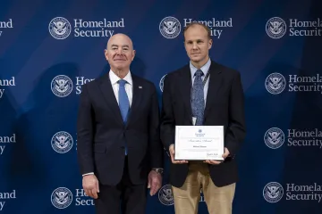 DHS Secretary Alejandro Mayorkas with Innovation Award recipient, Michael Huston.