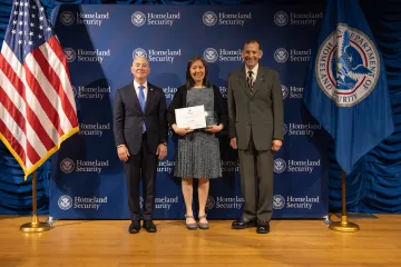 DHS Secretary Alejandro Mayorkas (left) with Innovation Award recipient, Annie Wong (center), and Deputy Under Secretary for Management, Randolph Alles (right).