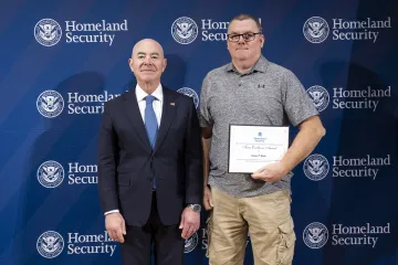 DHS Secretary Alejandro Mayorkas with Team Excellence Award recipient, James Rush.