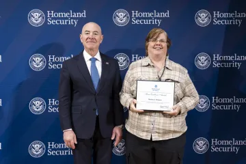 DHS Secretary Alejandro Mayorkas with Team Excellence Award recipient, Kathryn Simpson.