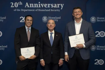 DHS Secretary Alejandro Mayorkas (center) with Innovation Award recipients, Matthew Closson (left) and Christopher Johnston (right).