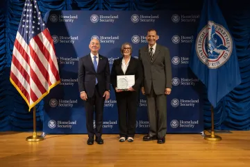 DHS Secretary Alejandro Mayorkas (left) with Innovation Award recipient, Dana Chisnell (center), and Deputy Under Secretary for Management, Randolph Alles (right).