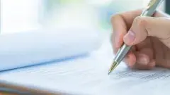 Man writing on paper with a pen