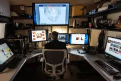 An ICE Cyber Crimes specialist works in a room that is setup to help identify child abusers and their victims.