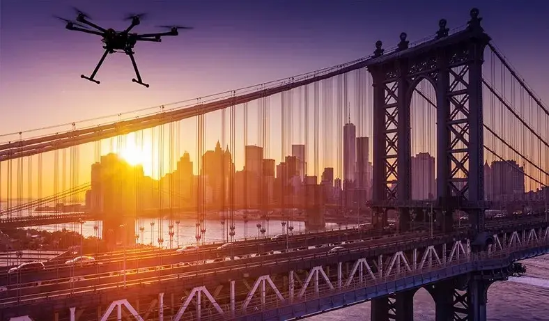 A drone flies over a New York City bridge.