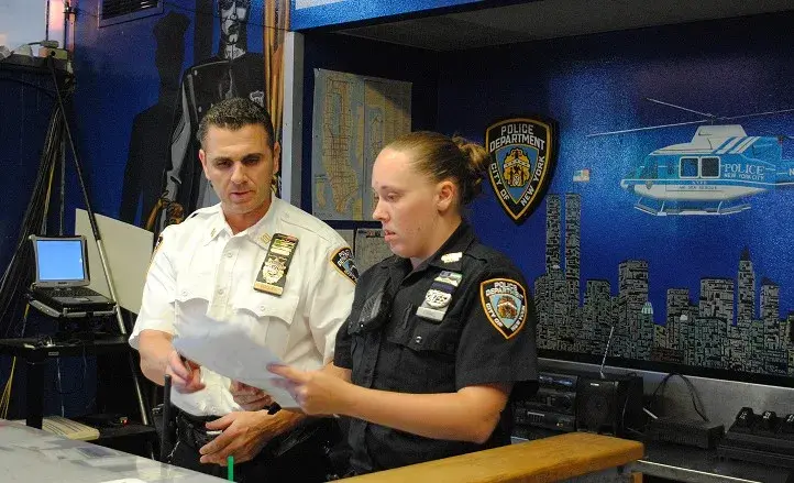 Captain Dan Dooley of the New York City Police Department (NYPD), pictured left in white uniform, standing with a woman police officer