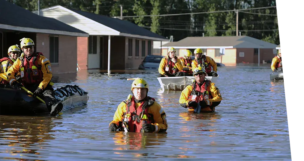 Emergency responders in high flood water rescuing people.