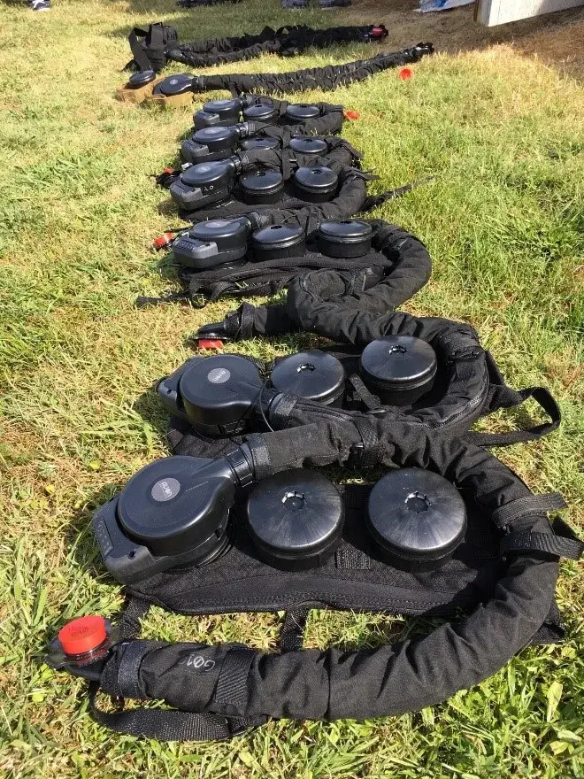 PAPRs lay on the grass before the test at MSRT East in Chesapeake, Virginia. The filters and air hoses are worn as backpacks. Photo by Don Bansleben, S&T.