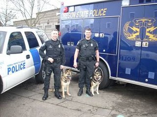 Inspectors stand by vehicles with dogs