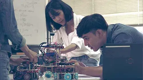 people working on a robot in a lab